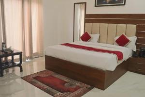 范兰德凡Guru Kripa sadan的一间卧室配有一张带红色枕头的大床