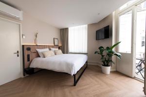马斯特里赫特波什斯坦什伯格酒店的一间卧室配有一张大床和盆栽植物
