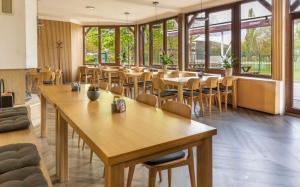 莫斯特Benedikt Most的餐厅设有木桌、椅子和窗户。