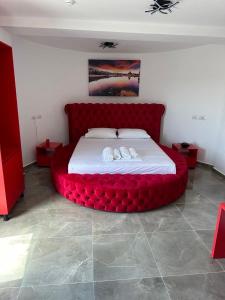 卡萨米尔Vullkan Hotel的一间卧室配有一张红色大床和两张毛巾