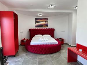 卡萨米尔Vullkan Hotel的一间卧室,卧室内设有一张红色的大床