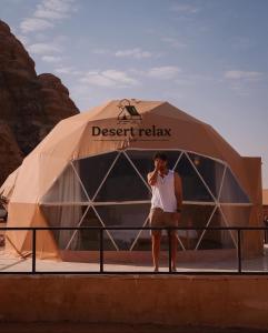 瓦迪拉姆Desert relax camp的帐篷前用手机说话的人
