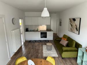 基亚索Smart Living Swiss的一间带绿色沙发的客厅和一间厨房