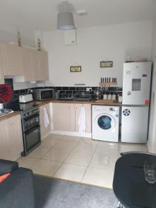 香农河畔卡里克Stunning 1-Bed Apartment in Carrick-On-Shannon的厨房配有炉灶、洗衣机和烘干机