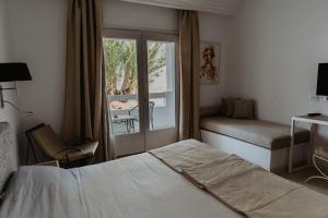 塔格梅斯Hotel Bougainvillier Djerba的酒店客房设有床和窗户。