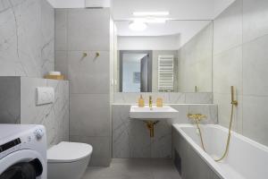 格丁尼亚04 Gdynia Premium - Apartament Mieszkanie dla 2 osób z parkingiem的一间带水槽、浴缸和卫生间的浴室