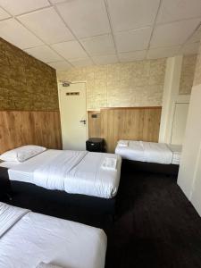 鹿特丹Flex-Inn的一间带三张床的卧室和一个带门的走廊