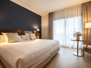 波多诺伏加拉蒂亚Spa酒店的一间卧室设有一张大床和一个大窗户