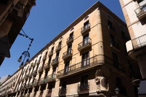 巴塞罗那Casa Pince的一座高大的建筑,旁边设有阳台
