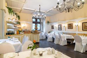 StaufenbergBurghotel Staufenberg的餐厅配有白色的桌椅和吊灯