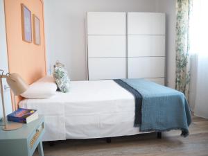 莫切Agua Salá A 200m de la playa zona tranquila的一间卧室配有一张白色的床和蓝色的毯子