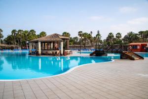 圣玛丽亚VOI Vila do Farol Resort的度假村的游泳池,设有凉亭和蓝色的水
