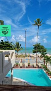 若昂佩索阿Kastel Jampa Hotel的棕榈树和海洋海滩上的游泳池