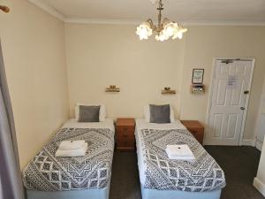 彼得伯勒Rose Marie Guest House的配有吊灯的客房内的两张床