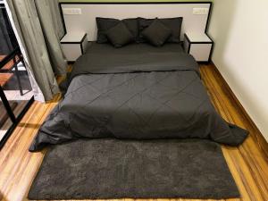 瓦亚纳德Jungle Woods 900kandi的一张带灰色棉被和枕头的床