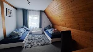 FriolzheimCosy Retreat in Friolzheim的一间卧室设有两张床和木墙