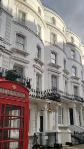 伦敦The J Hyde Park的白色建筑前的红色电话亭