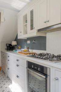 都柏林GuestReady - Victorian redbrick in heart of Dublin的厨房配有白色橱柜和炉灶烤箱。