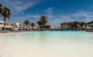 萨尔雷VOI Praia de Chaves Resort的一座棕榈树和建筑的大型游泳池