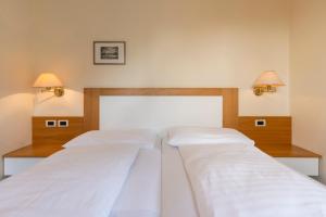 泰尔拉诺Weingarten Terlan - Rooms & Breakfast的两张床位于带两盏挂在墙上的灯的房间