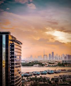 迪拜Golden Sands Boutique Hotel-Dubai Creek的享有城市天际线美景,设有一座高高的建筑