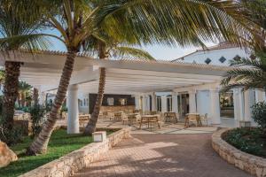 萨尔雷VOI Praia de Chaves Resort的一个带棕榈树和桌椅的庭院