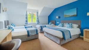 韦尔斯伍基洞酒店的蓝色墙壁客房的两张床