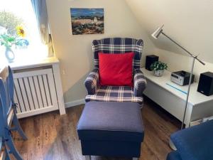 DunsumDeichhof Whg 27的室内的红色枕头椅子