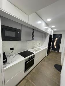 LibrazhetHOME 12的白色的厨房配有水槽和微波炉