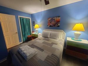 格尔夫海岸Beautiful 3 Bedroom BEACHFRONT Condo (F3) - Sleeps 10的一间卧室配有一张蓝色墙壁的床和两盏灯。