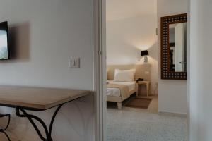 塔格梅斯Hotel Bougainvillier Djerba的客房设有床、桌子和镜子