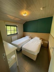 赫罗本东克Bouwelhoeve 't Schuur的小型客房的两张床,设有绿色的墙壁