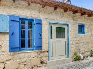 Arsos科尔纳罗乡村民宿的石头建筑上的蓝色门窗