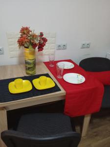 利沃夫Апартамент в Новобудові Стрийська Автовокзал的一张桌子,上面有两个盘子和红色桌布