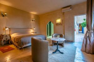Oulad BarrehilPrestige du Souss的卧室配有一张床和一张桌子及椅子