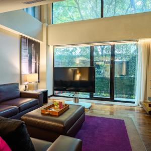 墨西哥城坎波斯艾里西欧司套房酒店的带沙发和大窗户的客厅