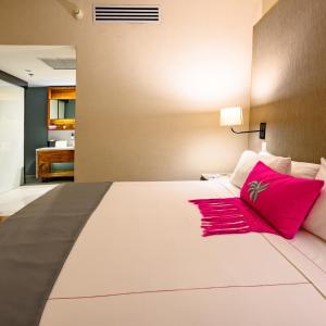 墨西哥城坎波斯艾里西欧司套房酒店的卧室配有带红色枕头的大型白色床