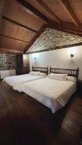 LoibaAldea Lamacido的砖墙房间内一张大白色的床