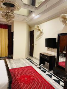 伊斯兰堡行政银河旅馆的一间带电视和红色地毯的客厅