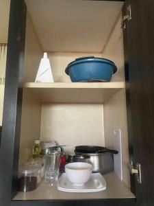 MéridaApartamento tipo estudio的橱柜,上面放一些碗和其他厨房用品