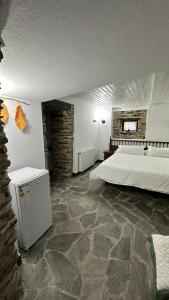 LoibaAldea Lamacido的一间卧室设有一张大床,铺有石质地板。