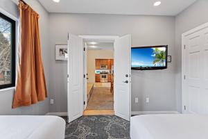 埃斯蒂斯帕克凯奥特山旅舍的一间卧室设有两张床,墙上配有电视。