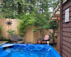尤克卢利特Forest Sweet Retreat Hot Tub & Wood Fired Sauna的后院的热水浴池,配有椅子和围栏