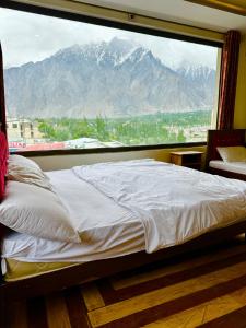 锡卡都Skardu Luxus Hotel的一张位于带大窗户的房间内的床铺