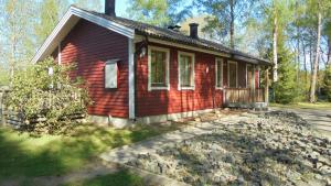 海斯勒霍尔姆Minnebo stuga的一堆石头的红色小房子