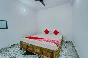 巴特那OYO Flagship Your Room & Guest House的一间卧室配有一张带红色枕头的床