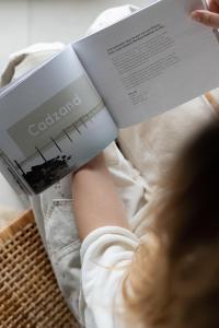 卡德赞德-班得北海酒店及水疗中心的一个人在床上读书