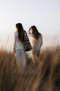 卡德赞德-班得北海酒店及水疗中心的两个女人穿过一片高大的草地