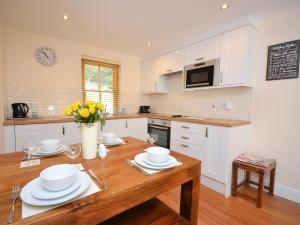 3 Bed in Narberth 36798的厨房配有白色橱柜和木桌