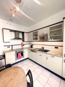 BonnevoieBerchem - Guest House的厨房配有白色橱柜和白色瓷砖地板。